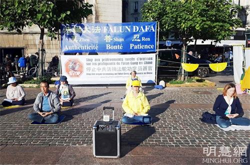 '圖1～2：二零二一年十月九日，巴黎法輪功學員在市中心的地鐵站夏特蕾（Chatelet Les Halles）門前廣場，舉辦了真相日活動。圖為法輪功學員在展示五套功法。'