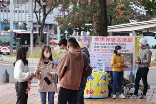 '圖4：有不少路人與學員交談、了解法輪功的真相。'