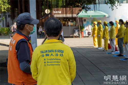 '圖10：蓮池潭風景區新任管理員吳先生（左）前來龍虎寶塔前廣場了解法輪功'