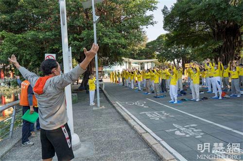 '圖11：工程師殷先生因腿傷請休假，順道來蓮池潭看風景，在此巧遇法輪功弘法。他模仿著跟大家煉了一會兒'