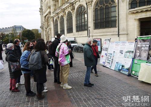 '圖7：二零二一年十一月六日，在夏特蕾地鐵站外，人們觀看法輪功展板，了解真相。'