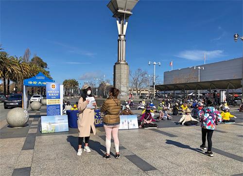 '圖1～2：二零二一年三月六日，舊金山部份法輪功學員來到渡輪大廈前的廣場集體煉功，告訴人們「法輪大法好，真善忍好」。'