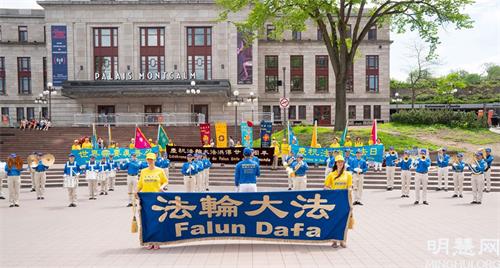 '圖2：二零二一年五月二十二日，法輪功學員在魁北克市中心舉行活動，慶祝世界法輪大法日暨法輪大法洪傳二十九週年。慶祝活動由法輪大法天國樂團雄壯的鼓號聲拉開帷幕。'