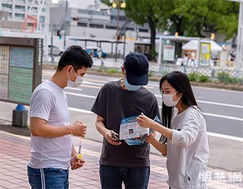 '圖3：二零二一年六月二十七日，法輪功學員們在向過路行人講法輪功真相'