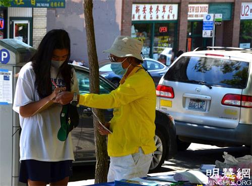 '圖2：西雅圖民眾在結束中共迫害法輪功的徵簽表上簽名。'