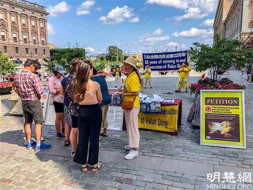 '圖1：法輪功學員在斯德哥爾摩市中心國會大廈旁舉辦「法輪功反迫害二十二週年」講真相活動。'