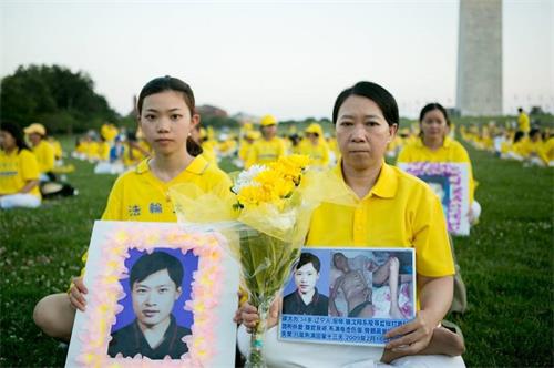 '徐鑫洋（左）與母親遲麗華（右）手捧父親徐大為的遺像'