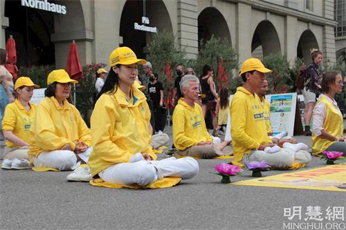 '圖3～5：法輪功學員在鬧市中功法演示，給人帶來一份平靜、祥和。'