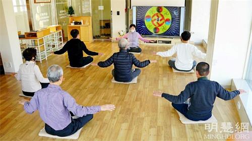 '圖1：二零二二年一月四日到十二日，韓國首爾天梯書店在開業六年以來迎來了第100屆「法輪大法九天學習班」。圖為參加二零二一年十一月份九天班的人們學習法輪大法第五套功法的場景。'