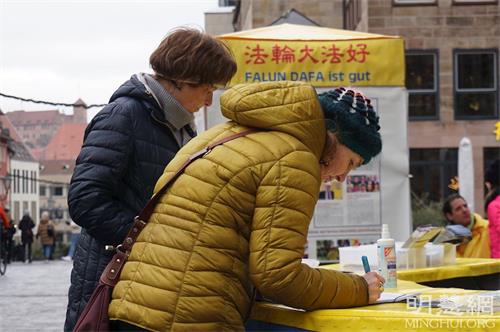 '圖2～4：二零二二年一月十五日，弗蘭肯地區的部份學員在紐倫堡傳播真相，民眾了解真相後，簽名支持法輪功學員反迫害。'