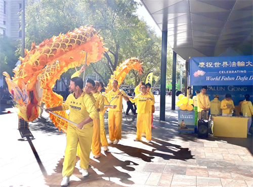 '圖4～5：西澳法輪功學員在珀斯市中心步行街上以舞龍表演來慶祝法輪大法傳世三十週年'