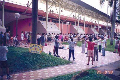 '圖11：自一九九五年起，法輪大法在海外洪傳，新加坡全島各地陸續成立了煉功點。很多當年的老學員就是在煉功點上入道得法的。圖為一九九八年學員們在金文泰體育場煉功點集體煉功。'