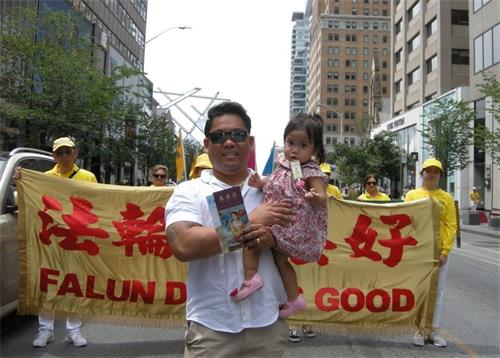 '圖10：多倫多建築公司協調人安多尼奧﹒阿爾西亞里奧（Andonio Alciario）先生和女兒高興的和遊行隊伍合影'