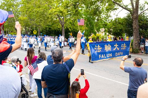 圖10：法輪功學員的隊伍經過時，觀眾一起歡呼：法輪大法