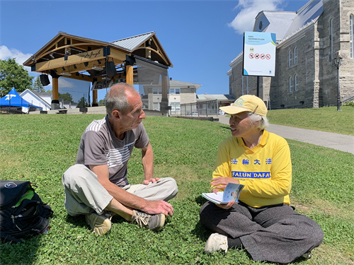 圖8: 退休電工讓-馬克（Jean-Marc）對法輪功很感興趣，他與法輪功學員交談良久。