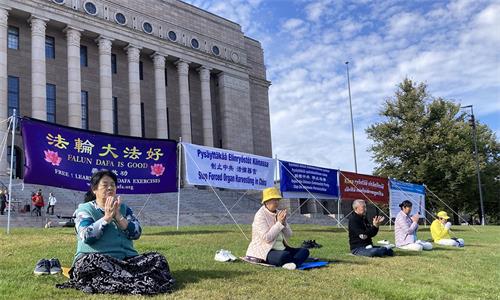 圖1：學員們在國會前懸掛「法輪大法好」、「制止中共 活摘器官」、「解體中共 停止迫害」 等橫幅