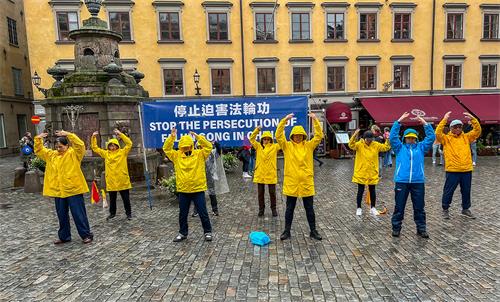 圖5：九月十七日週六下午，法輪功學員在諾貝爾博物館前舉辦活動，學員們冒雨展示法輪功的五套功法。